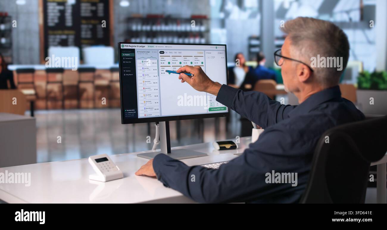 Il responsabile della vendita al dettaglio traccia in modo efficiente le vendite giornaliere utilizzando il sistema POS touchscreen. Foto Stock