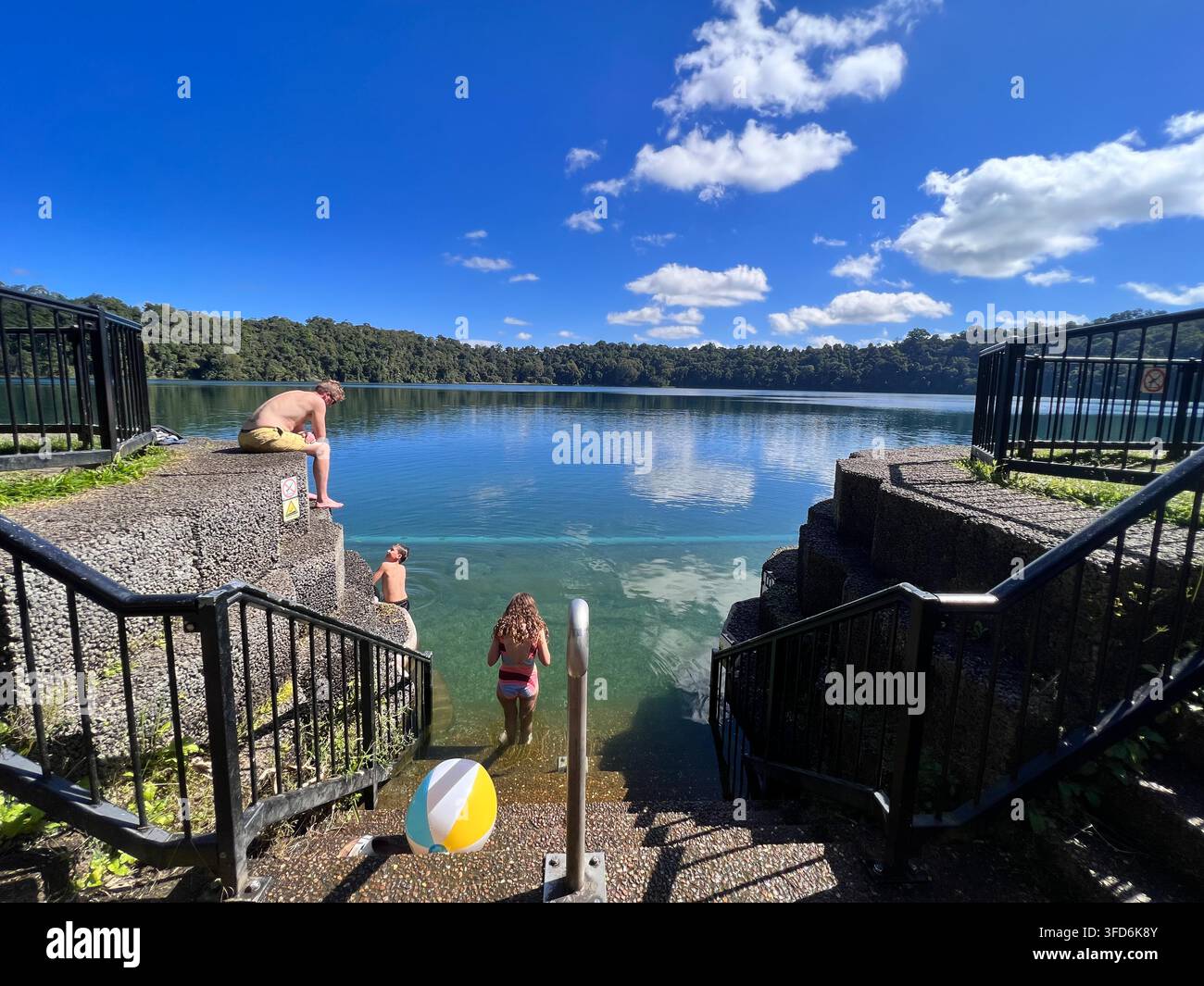 CAIRNS, QLD - 28 GIUGNO 2023: Australiani nuotano nel lago Eacham, un lago popolare di origine vulcanica sull'altopiano di Atherton nella zona tropicale dell'estremo nord dell'Australia Foto Stock