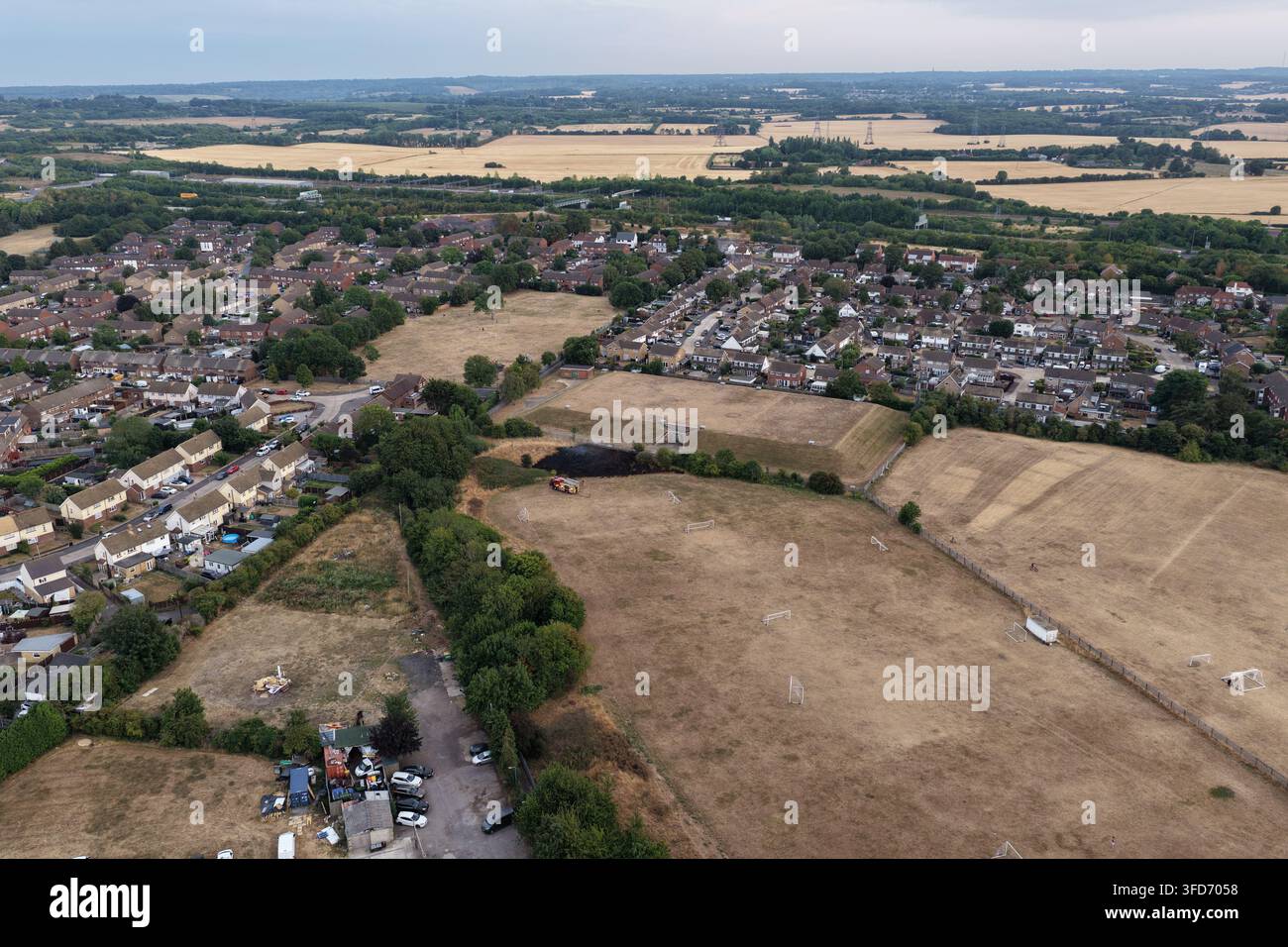 I vigili del fuoco affrontano un incendio di erba accanto ai campi da calcio giovanili del Guru Nanak FC a Gravesend, nel Kent, in condizioni calde e asciutte, il 3 agosto 2026. Foto Stock
