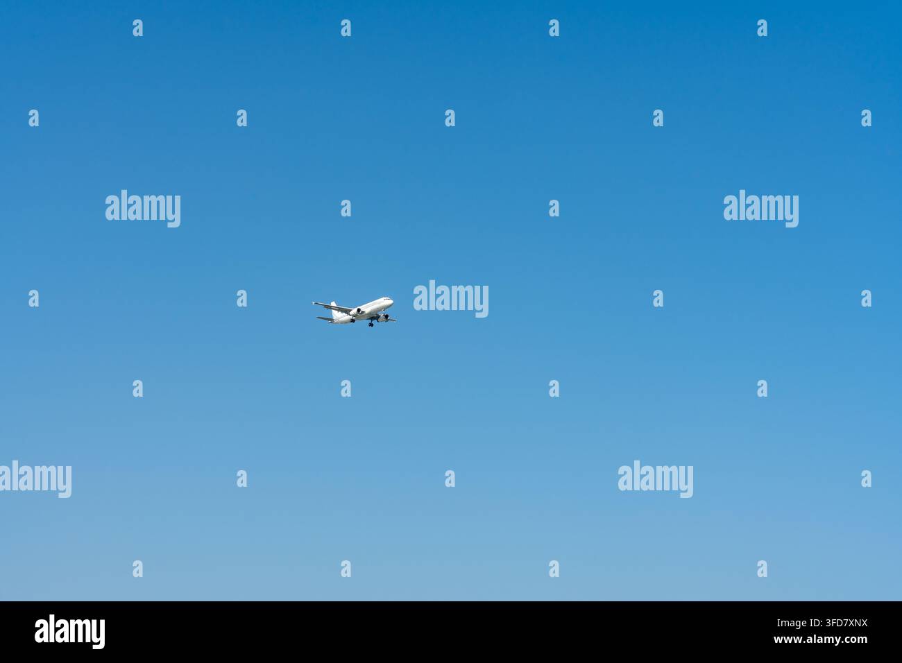 Vista ad angolazione bassa di un aereo passeggeri commerciale che vola in alto in un cielo blu limpido, che mostra il trasporto aereo con ampio spazio per il testo Foto Stock