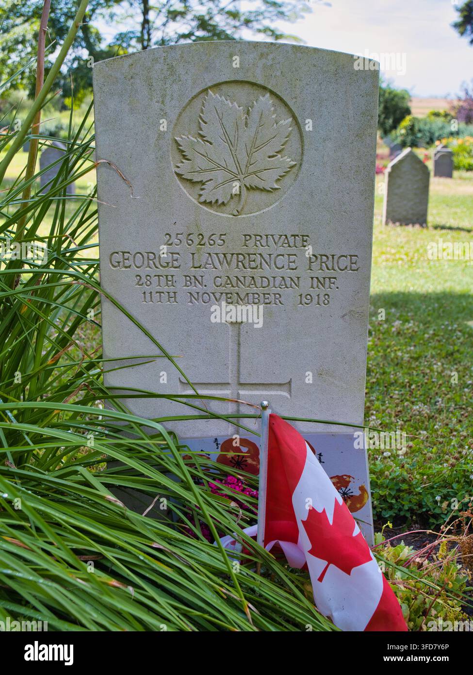 Saint-Symphorien, Belgio - 29 giugno 2026: Tomba del soldato semplice canadese George Lawrence Price in un cimitero della Prima Guerra Mondiale a Saint Symphorien, Belgio, contrassegnata da una bandiera canadese e da una lapide a forma di foglia d'acero Foto Stock
