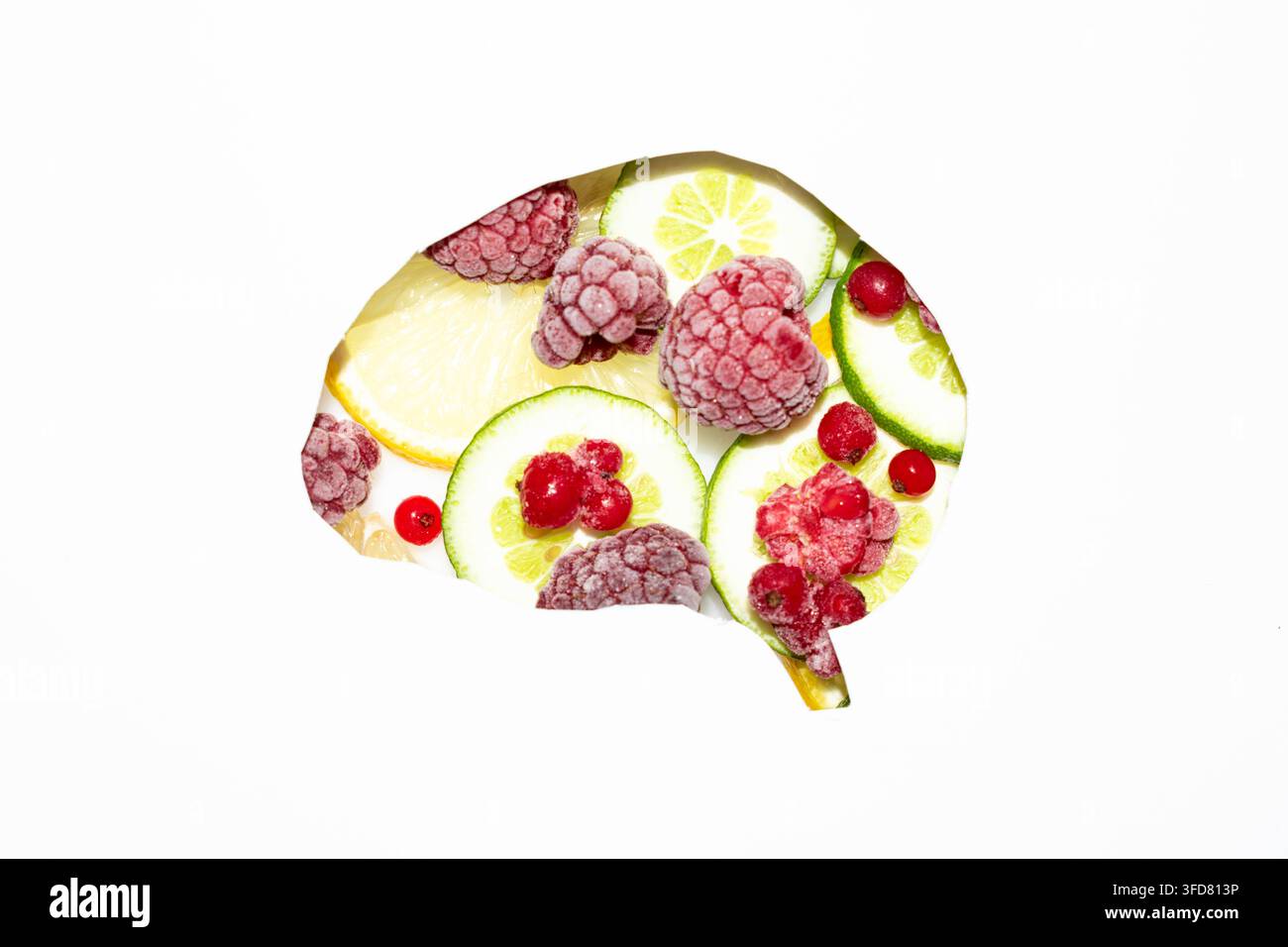 Concetto creativo di cervello sano formato da frutta fresca, bacche, fette di agrumi e noci su uno sfondo bianco pulito con spazio per il testo. Foto Stock