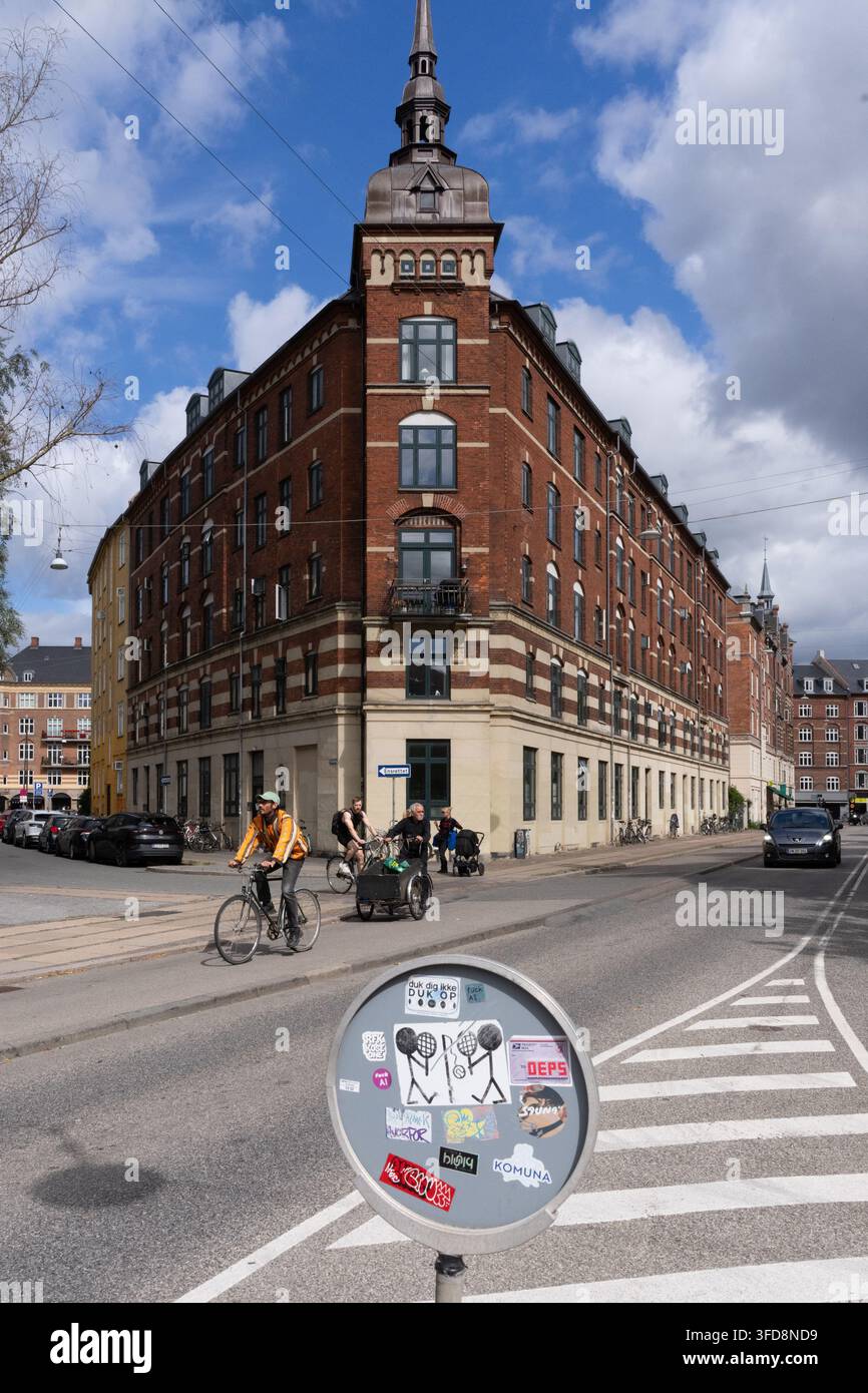 I pendolari passano in bicicletta davanti all'edificio a forma di cuneo, punto di riferimento a Copenaghen. Foto Stock