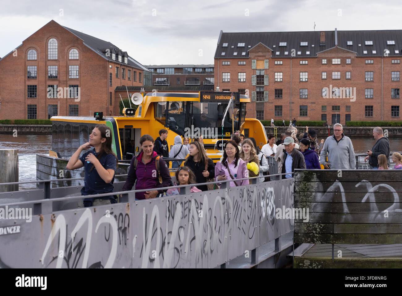I passeggeri sbarcano da un bus giallo del porto di Copenaghen alla stazione Det Kongelige Bibliotek (Københavns Havn), utilizzando il trasporto pubblico basato sull'acqua della città Foto Stock