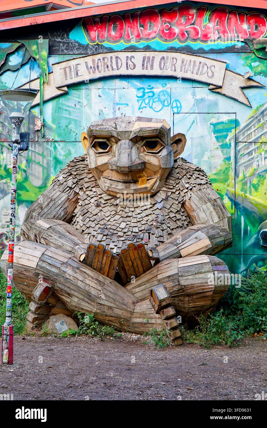 Green George, una scultura gigante di troll dell'artista danese di arte riciclata Thomas Dambo, seduto davanti al murale "Il mondo è nelle nostre mani" di Rasmus Balstrøm, F Foto Stock