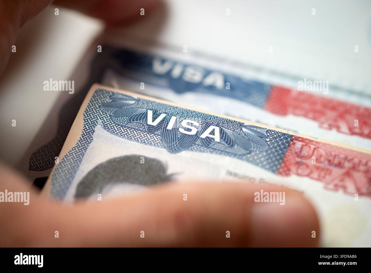Timbro del visto degli Stati Uniti all'interno di un documento di passaporto aperto, tenuto da una mano, per immigrazione, viaggi internazionali, sicurezza dei confini, richiesta di visto e temi di cittadinanza. Foto Stock
