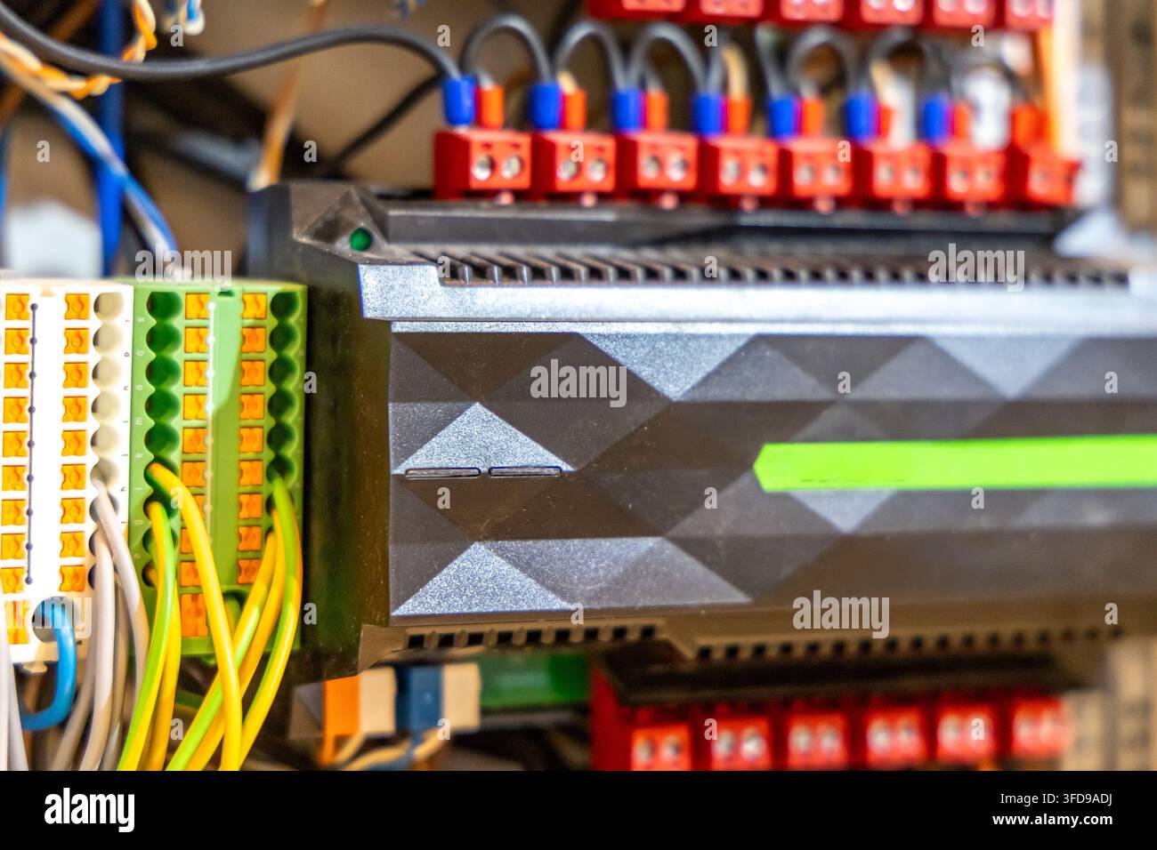 Vista dettagliata dei collegamenti elettrici e dei moduli all'interno di un pannello di controllo industriale, evidenziando il cablaggio intricato e l'hardware elettronico Foto Stock