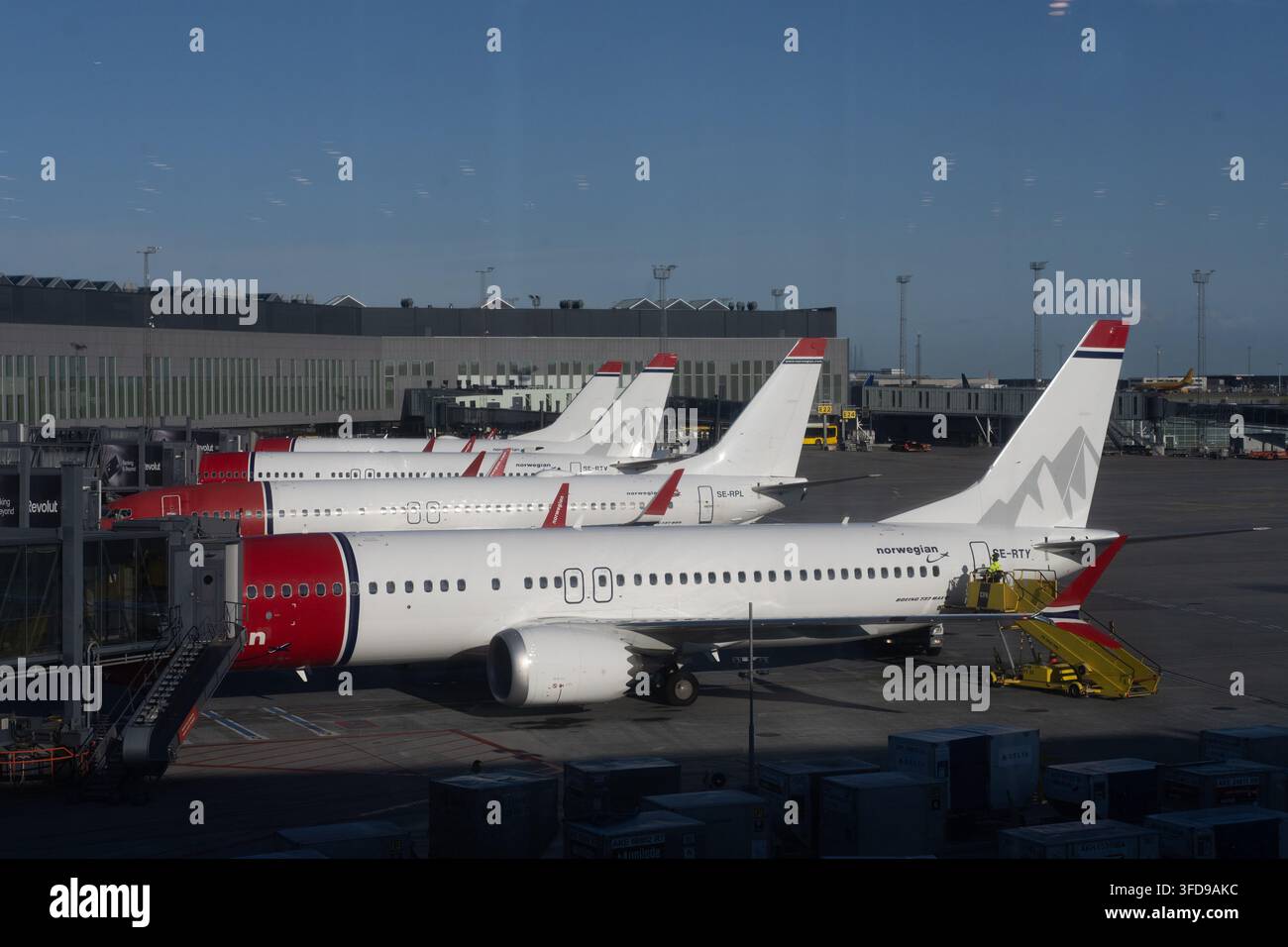 I jet di Norwegian Air Shuttle ai loro gate all'aeroporto di Copenaghen (CPH) per il servizio a terra di routine e l'imbarco dei passeggeri. Foto Stock