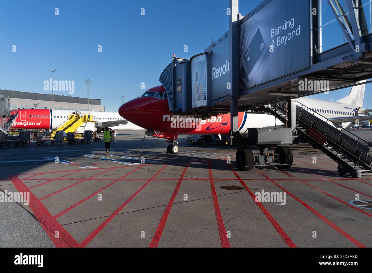 Il personale di terra all'aeroporto di Copenaghen gestisce le operazioni di imbarco per gli aerei di Norwegian Air Shuttle collegati a una passerella del terminale. Foto Stock