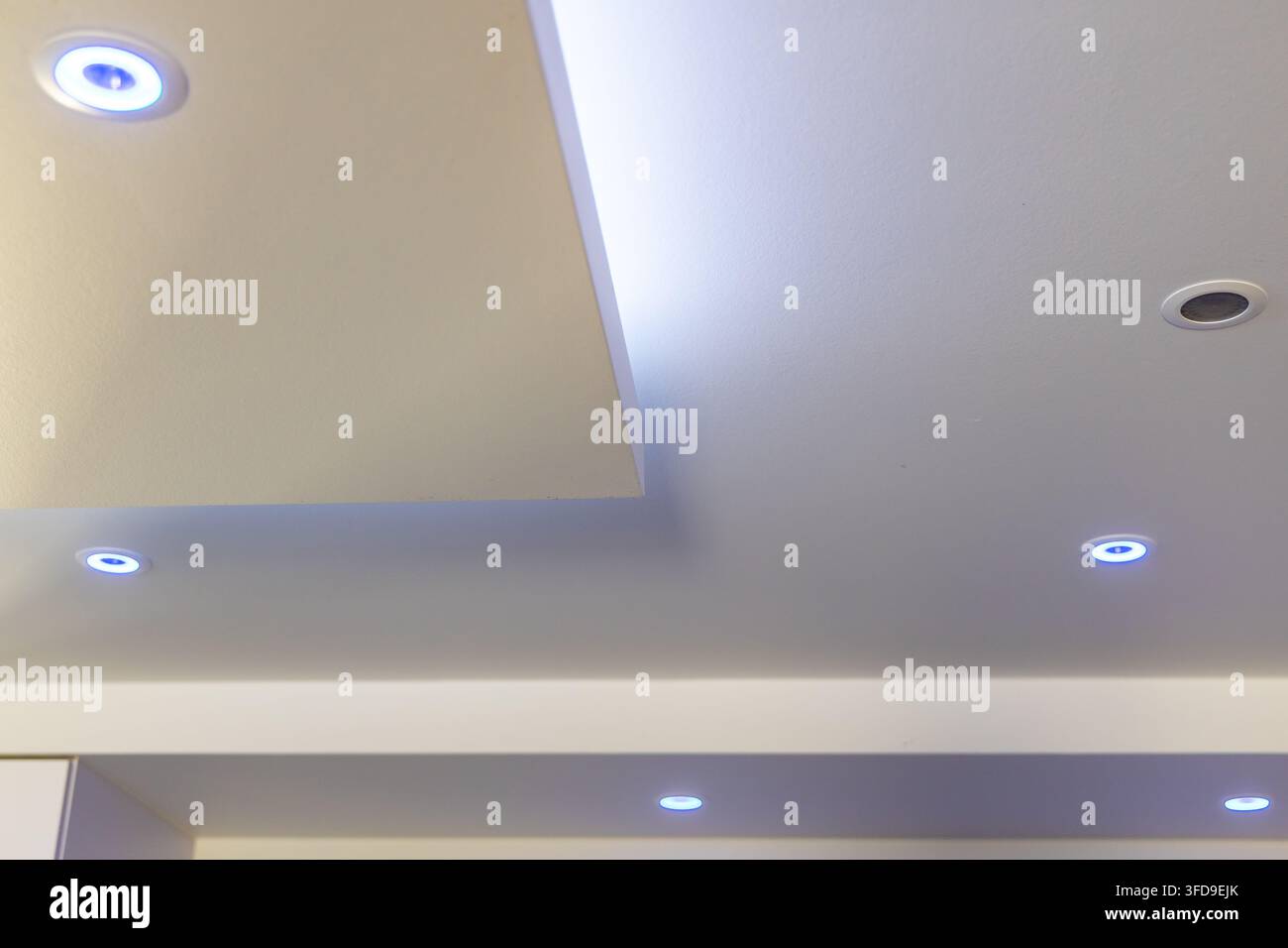 Lampade da soffitto incassate con design contemporaneo, caratterizzate da una morbida illuminazione LED blu per un'atmosfera sofisticata Foto Stock