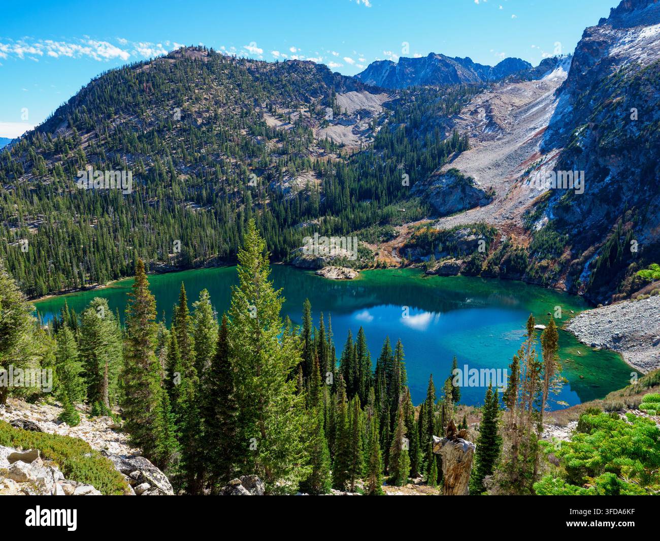 Lago alpino nelle Sawtooth Range Mountains dell'Idaho con acque limpide e molti alberi Foto Stock