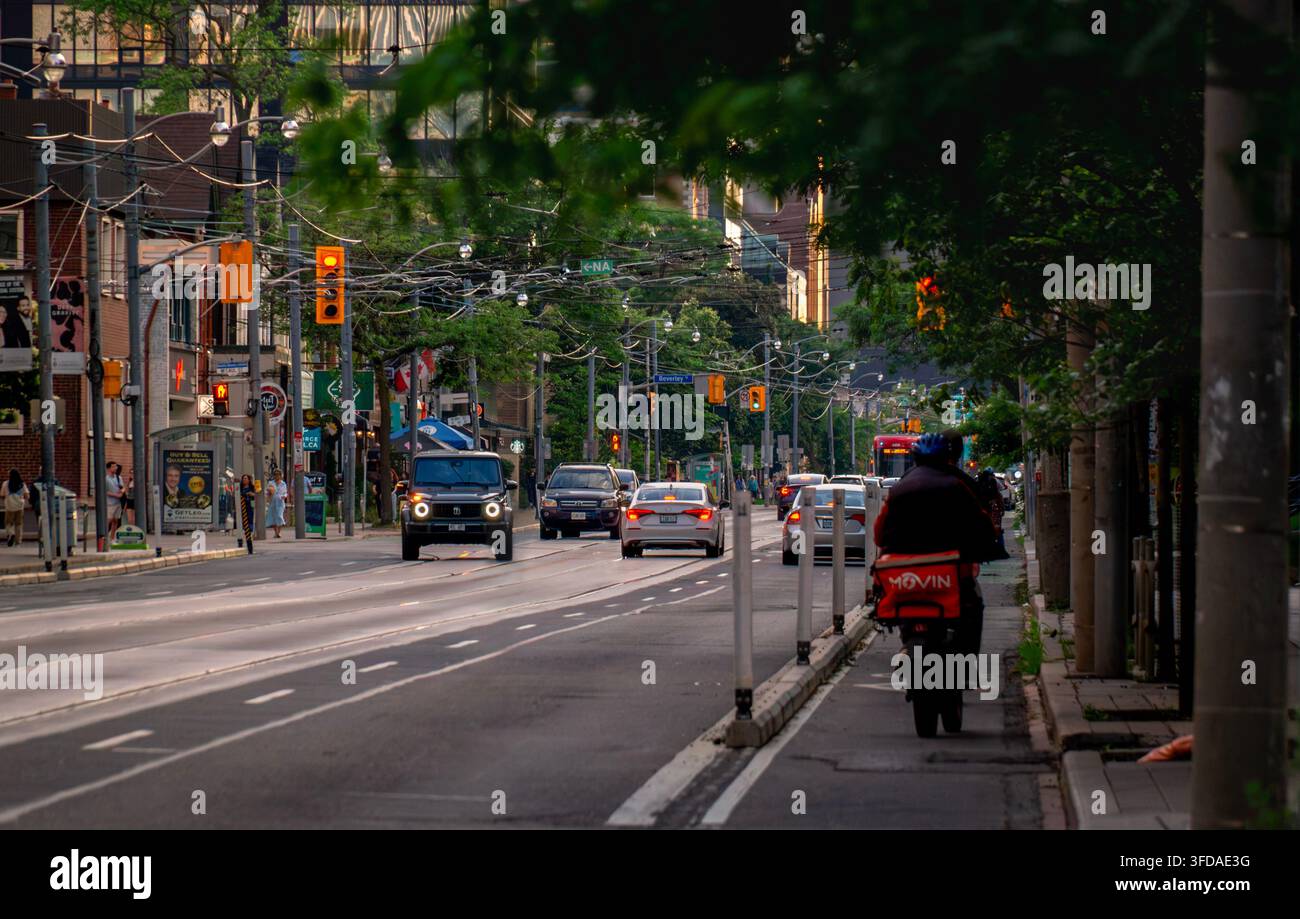 Toronto, Ontario, Canada – 06 21 2025: Scenario di traffico urbano diurno su Queen Street West vicino a Beverley Street nel centro di Toronto con auto incl Foto Stock
