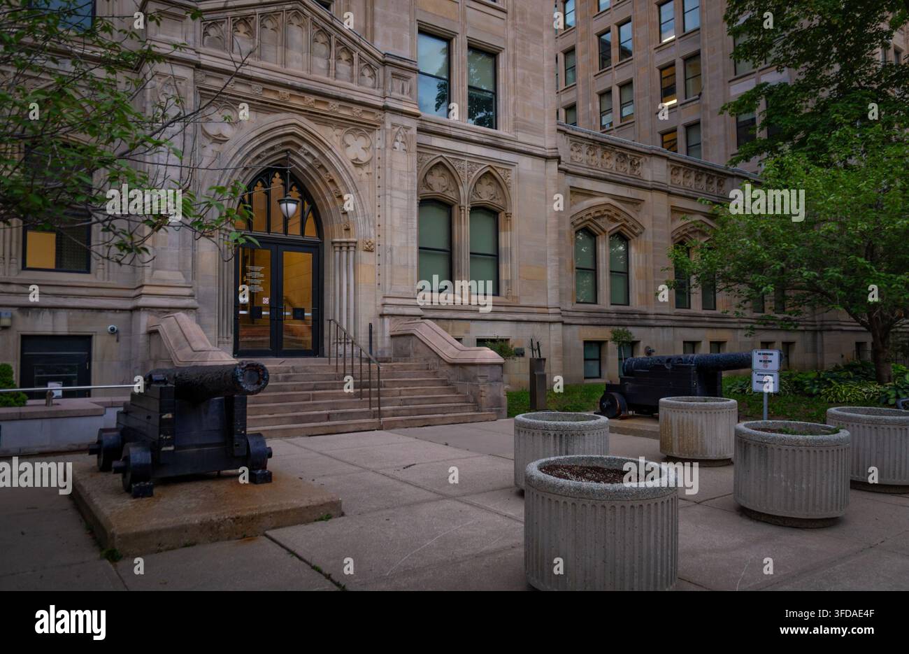 Toronto, Ontario, Canada – 06 21 2025: Vista esterna dell’historic University College nel campus dell’Università di Toronto, con cannoni storici Foto Stock