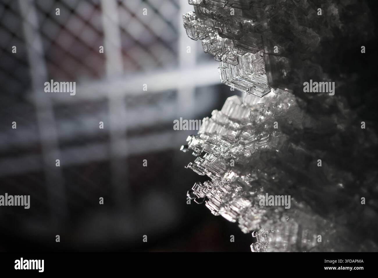 Una superficie ghiacciata congelata da cristalli di ghiaccio texture macro invernale argento riflettente ghiaccio freddo nel congelatore per ghiaccio Foto Stock