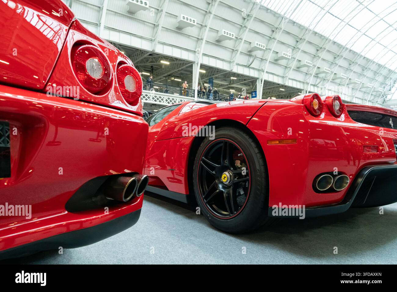 Londra, Regno Unito - 22 febbraio 2020: Due supercar rosse Ferrari esposte insieme in un salone dell'automobile, fotografate da un angolo basso posteriore. Foto Stock