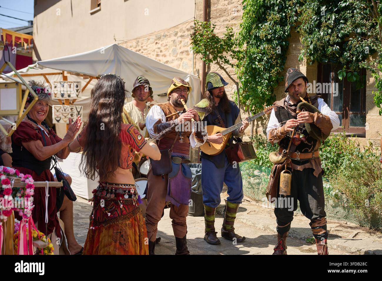 08-14-2026, Puebla de Sanabria, musicisti medievali in costumi storici suonano strumenti tra cui cornamuse e un liuto, mentre ballerini in trad Foto Stock