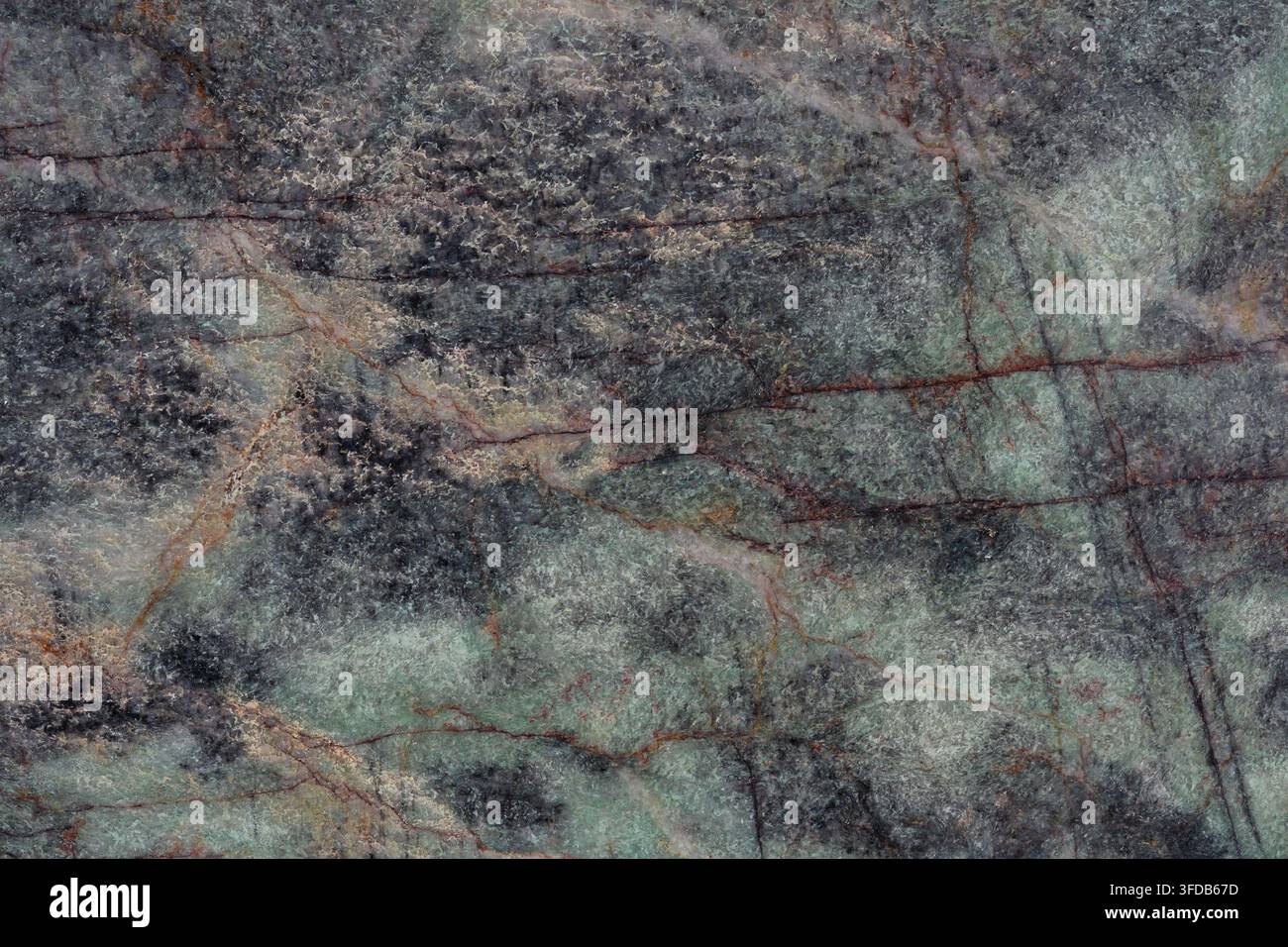Primo piano di una lastra di pietra di quarzite verde lucidata che mostra motivi minerali grigio scuro ed smeraldo attraversati da sottili venature rosso ruggine, pietra naturale Foto Stock