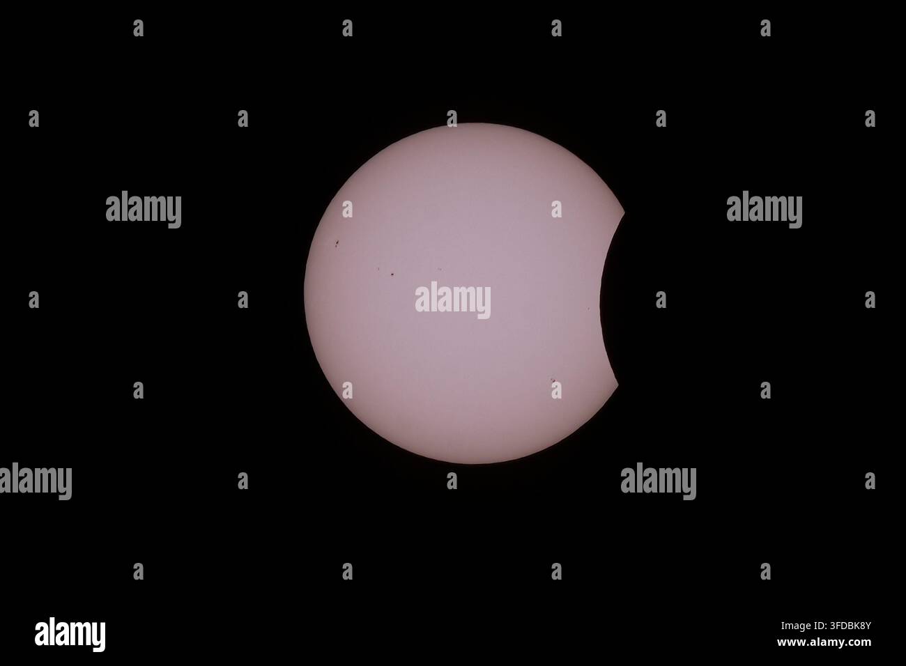 Fase parziale iniziale dell'eclissi solare totale del 12 agosto 2026, primo contatto della luna che copre il disco solare con macchie solari. Foto Stock