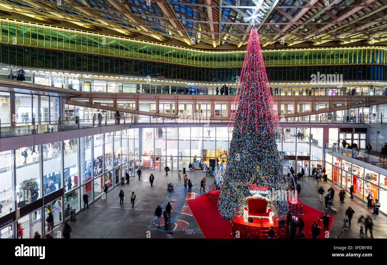 Parigi, Francia - 24 dicembre 2025: Grande albero di Natale decorato con luci brillanti all'interno del centro commerciale Forum des Halles. Foto Stock