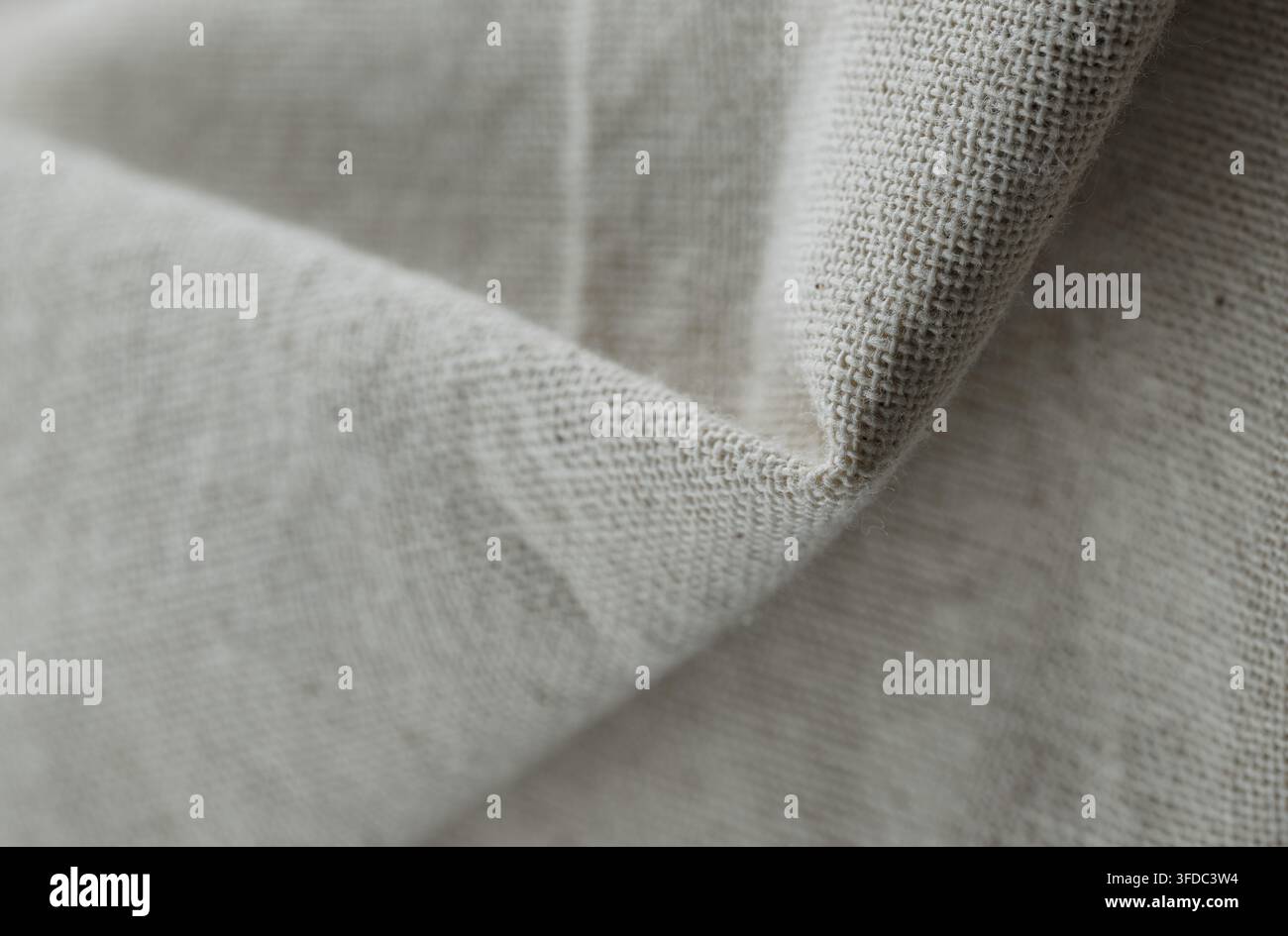 Tessuto di lino naturale che mostra una trama intricata, pieghe sottili e un colore beige neutro Foto Stock