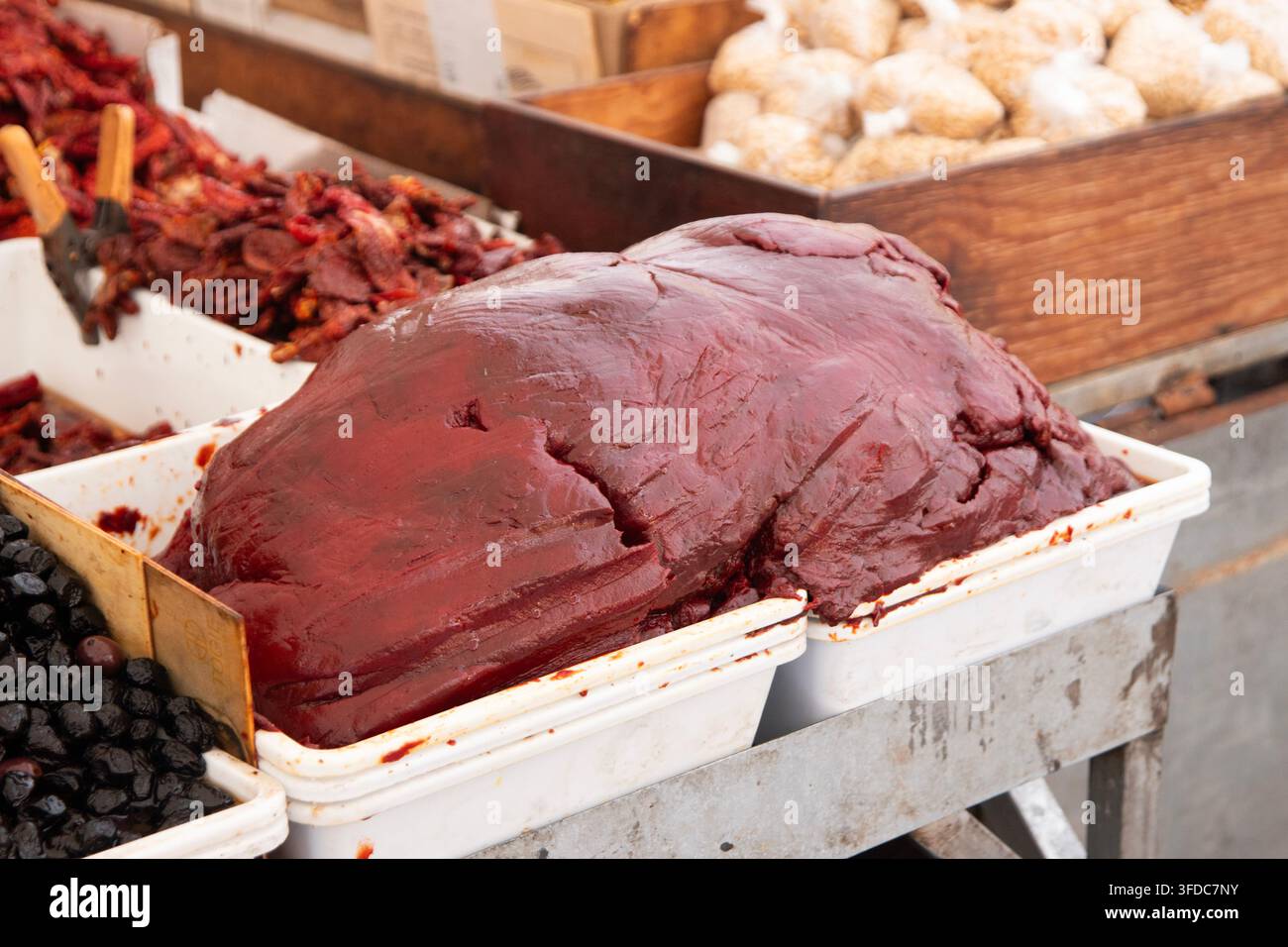 Lo Strattu è una pasta di pomodoro estremamente densa, scura e ricca di umami, ottenuta disidratando pura di pomodoro fresca con sale. Foto Stock