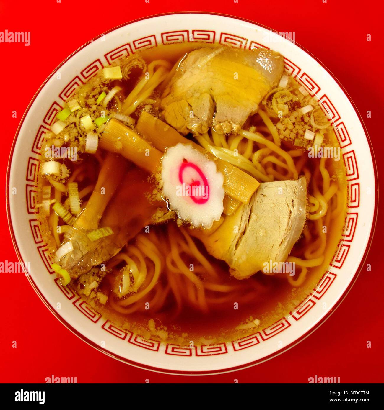 Una deliziosa ciotola di ramen shoyu giapponese tradizionale con brodo di salsa di soia saporito, noodles arricciati, tenero maiale chashu, germogli di bambù e narutomak Foto Stock