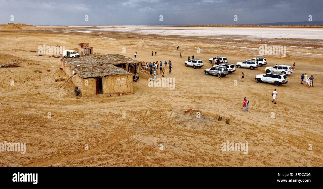 Vista panoramica del luogo di ripresa iconico di Mos Espa per Star Wars con gruppo di turisti e veicoli 4x4 parcheggiati nelle pianure desertiche di Ong Jmal. Scattato il Foto Stock