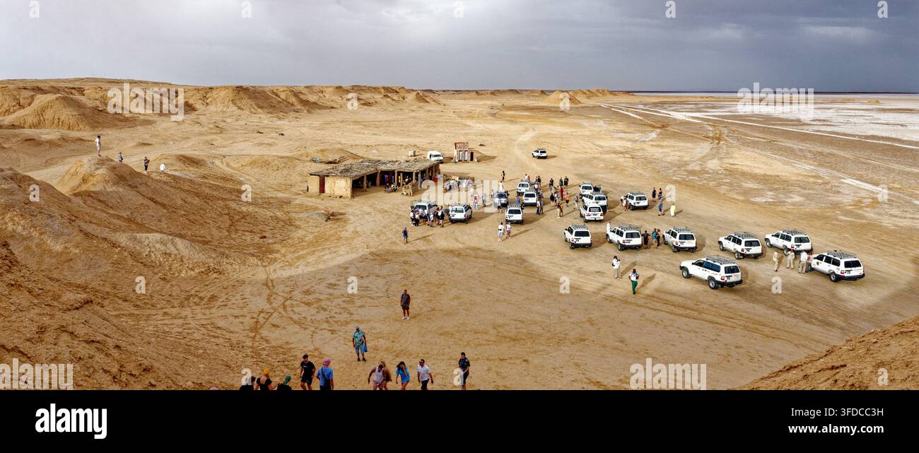 Vista panoramica del luogo di ripresa iconico di Mos Espa per Star Wars con gruppo di turisti e veicoli 4x4 parcheggiati nelle pianure desertiche di Ong Jmal. Scattato il Foto Stock