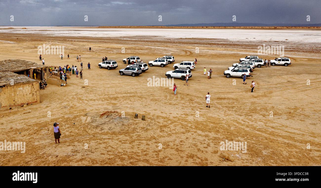 Vista panoramica del luogo di ripresa iconico di Mos Espa per Star Wars con gruppo di turisti e veicoli 4x4 parcheggiati nelle pianure desertiche di Ong Jmal. Scattato il Foto Stock