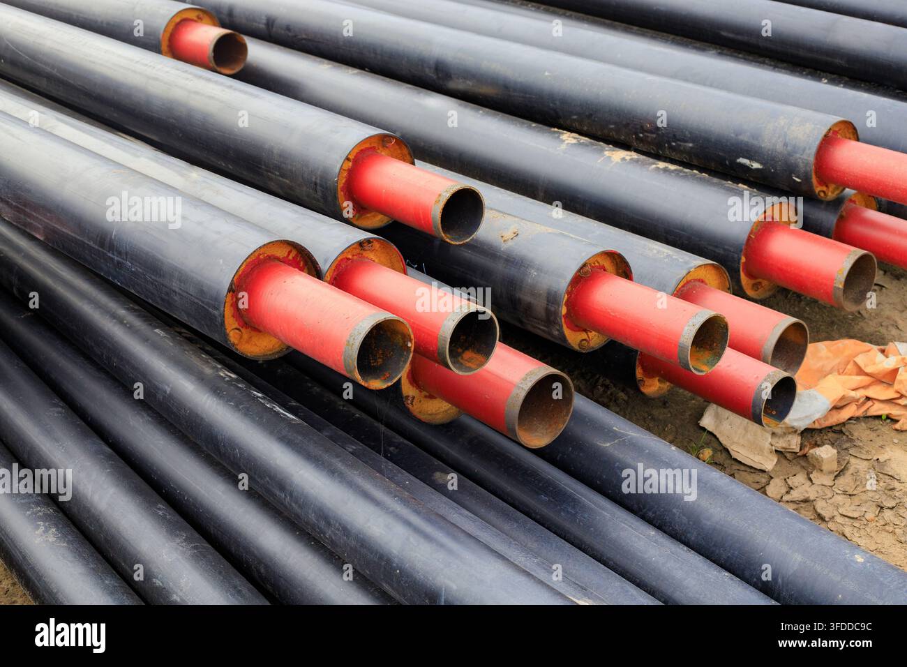Tubi di acciaio per riscaldamento impilati sull'erba. Modernizzazione delle utenze, installazione del sistema di riscaldamento e materiali da costruzione. Foto Stock