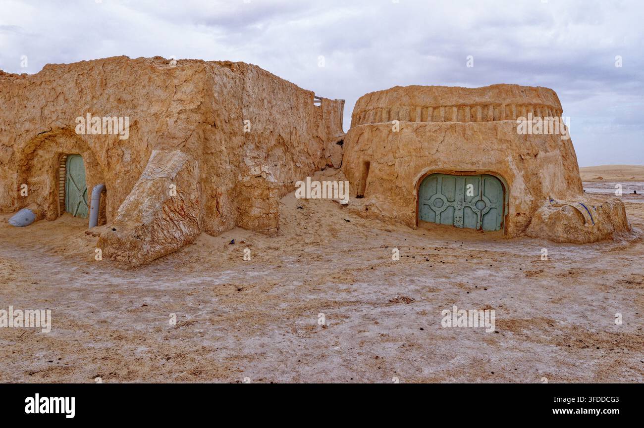 Edifici in gesso abbandonati con pareti in fango strutturate e porte verde menta distintive presso il luogo di riprese di Mos Espa Star Wars a Hammat-al-Jari Foto Stock