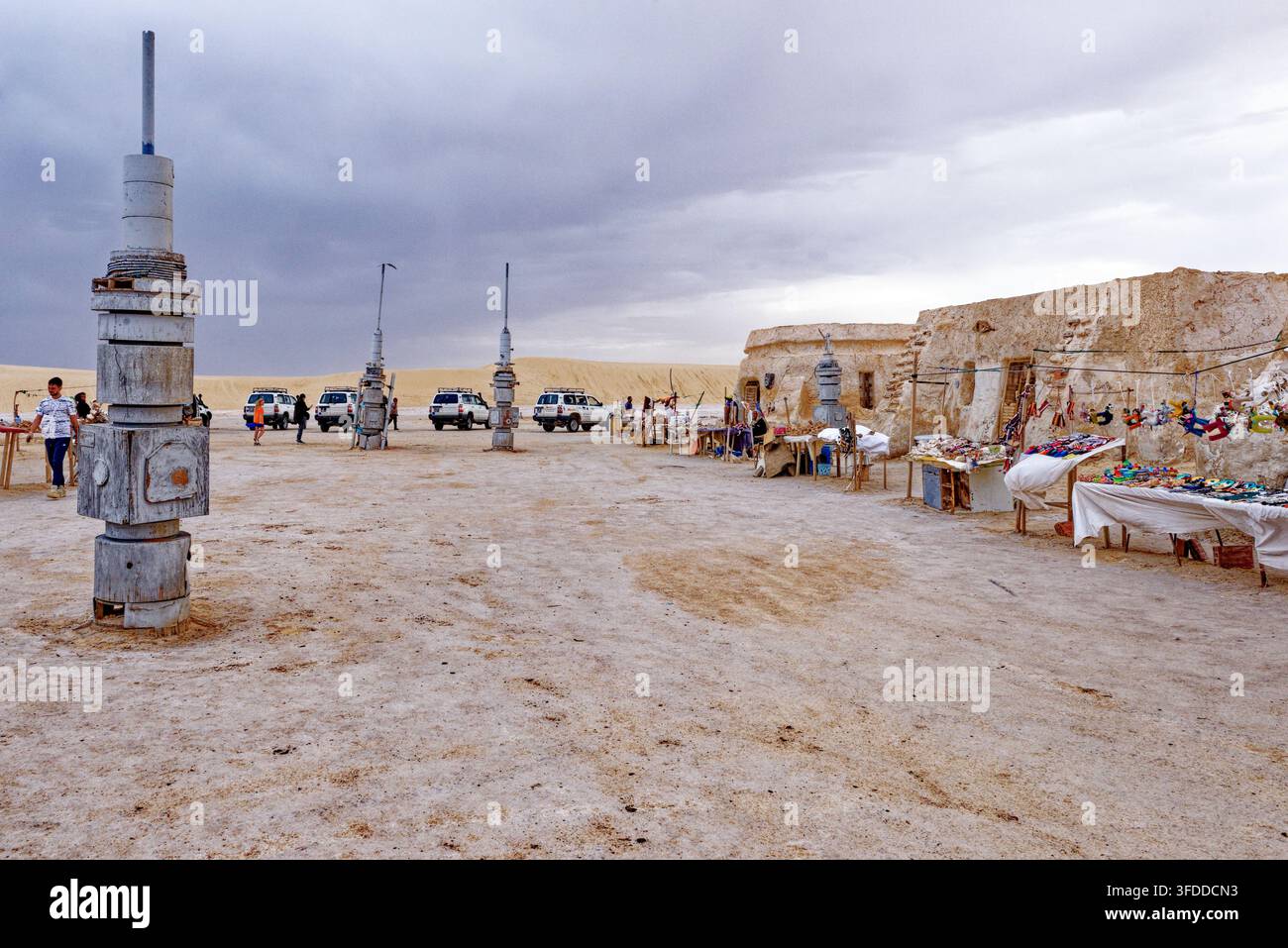 Banchi dei venditori di souvenir locali allineati davanti agli edifici intonacati con fango al set di Star Wars di Mos Espa ad Hammat-al-Jarid. Captur Foto Stock