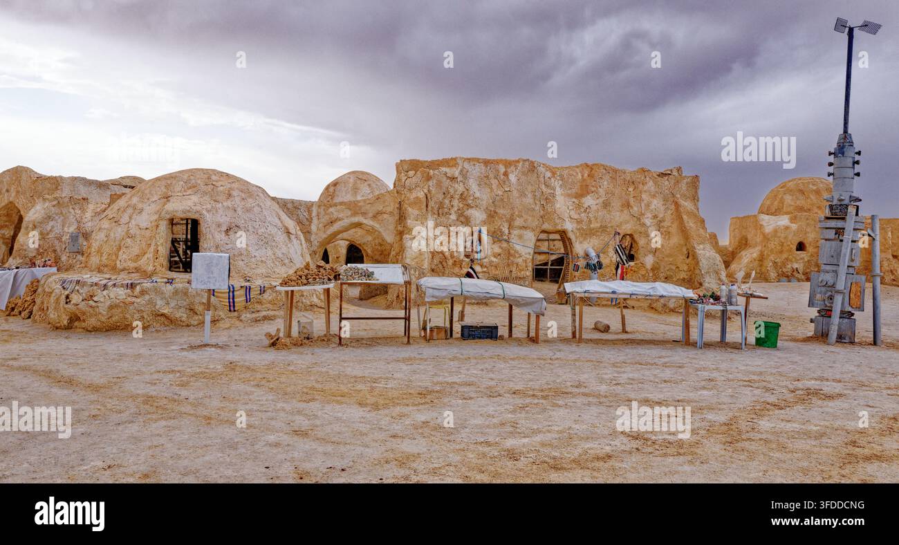 Banchi dei venditori di souvenir locali allineati davanti agli edifici intonacati con fango al set di Star Wars di Mos Espa ad Hammat-al-Jarid. Captur Foto Stock