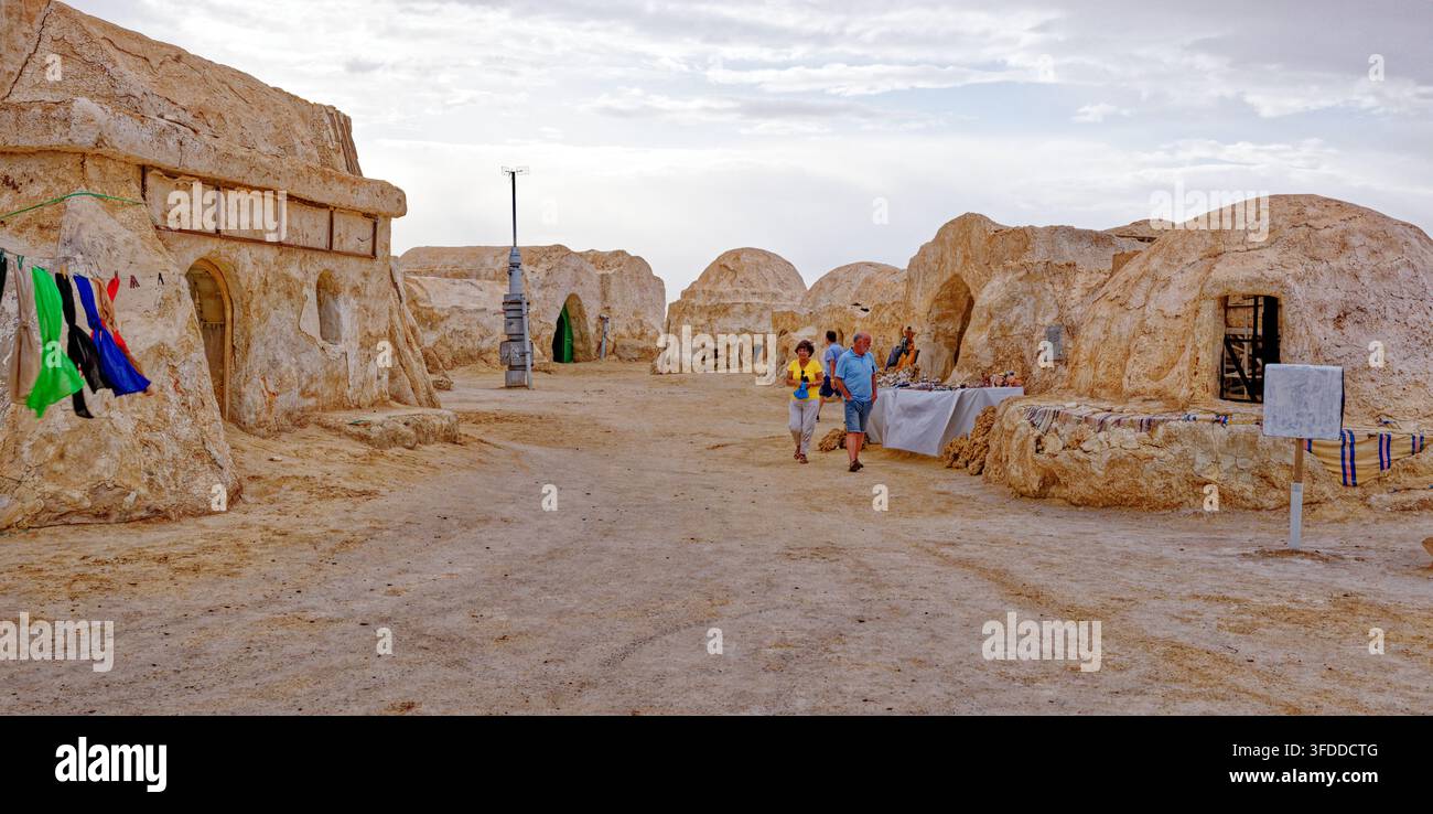 Banchi dei venditori di souvenir locali allineati davanti agli edifici intonacati con fango al set di Star Wars di Mos Espa ad Hammat-al-Jarid. Captur Foto Stock