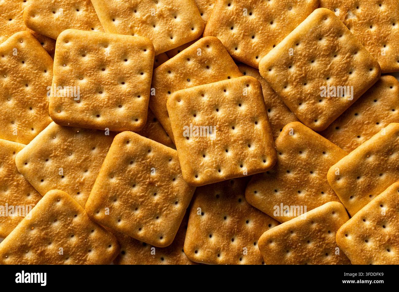 Pila di cracker quadrata d'oro con vista dall'alto a cornice completa, snack centrali e croccante tostata Foto Stock