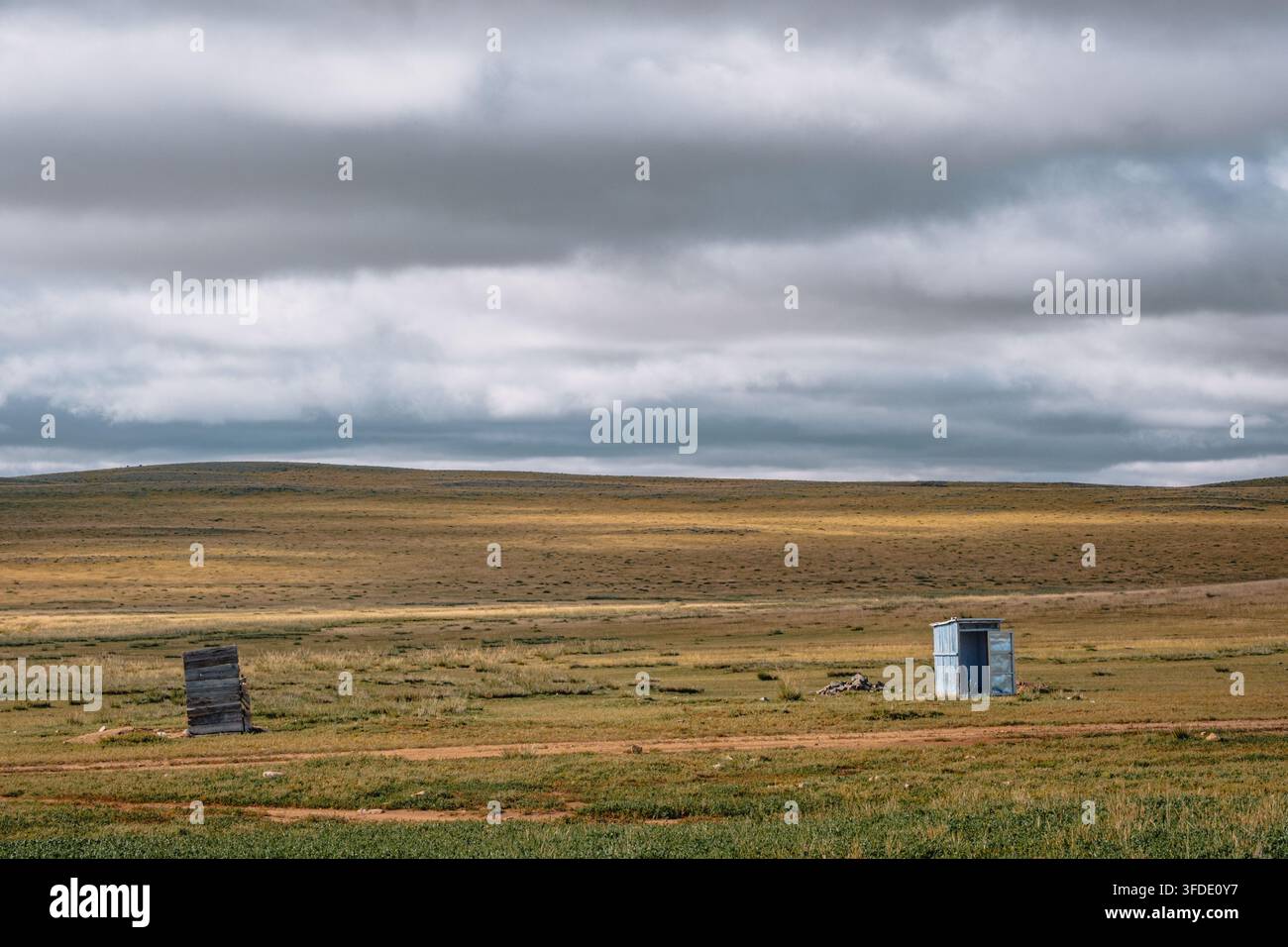 Semplici toilette all'aperto in un accampamento nomade nella vasta steppa mongola sotto un drammatico cielo nuvoloso. Foto Stock