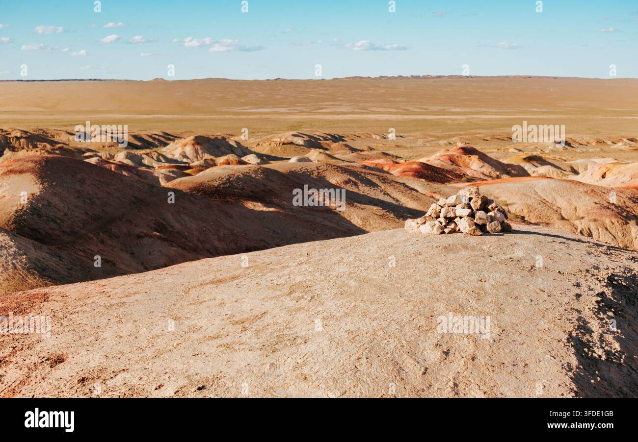 Luce dorata della sera sulle badlands erose di Tsagaan Suvarga, Stupa Bianca, Mongolia, con un piccolo cumulo di pietre. Foto Stock