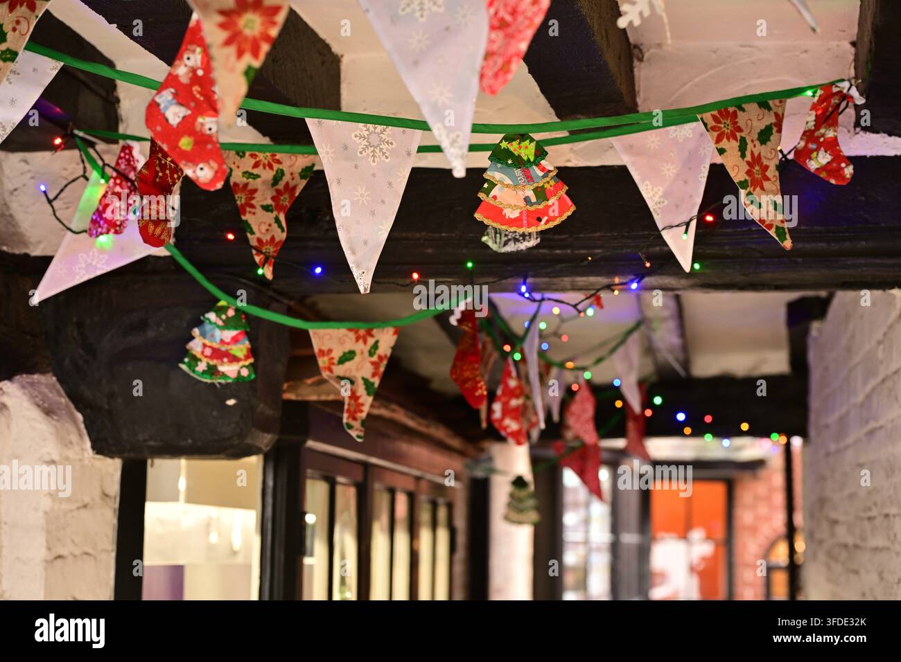 Accogliente corridoio interno decorato con bandierine natalizie, calze e luci festive multicolori Foto Stock