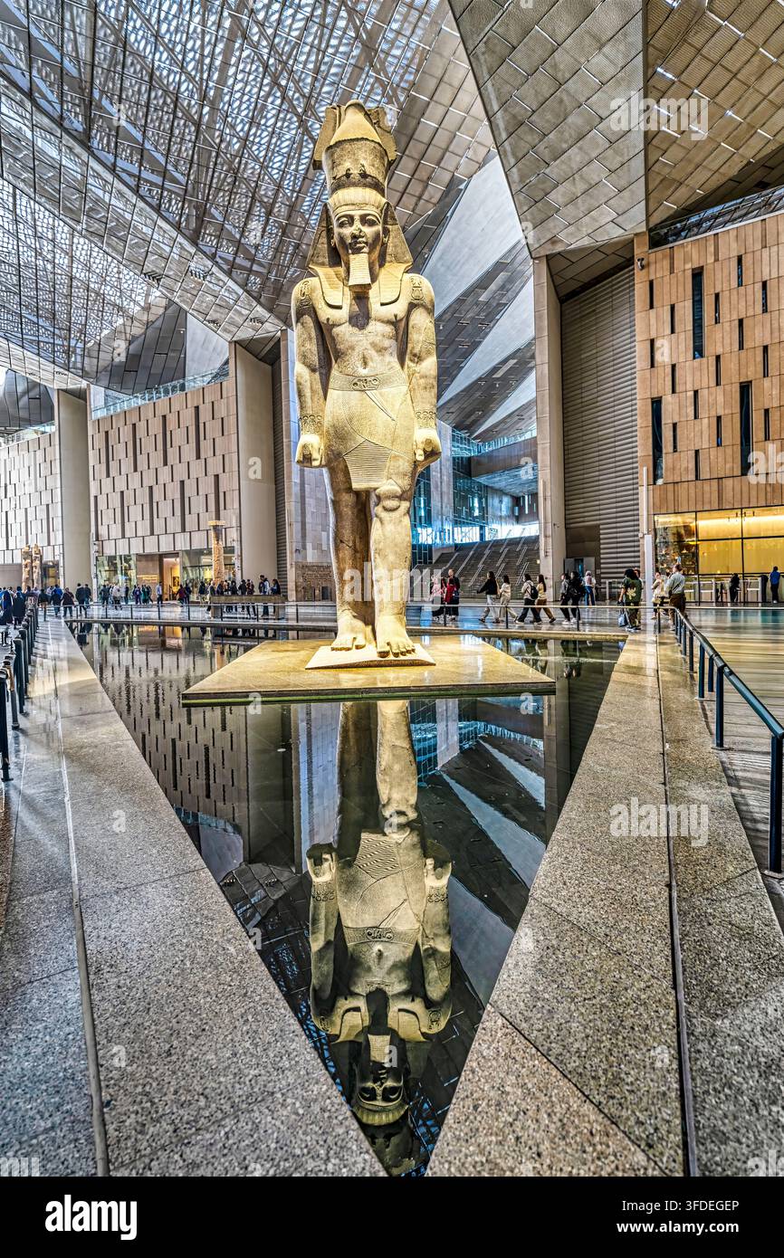 La statua del faraone Ramses II riflessa nella piscina del Grande Salone del Grande Museo Egiziano al Cairo. Foto Stock