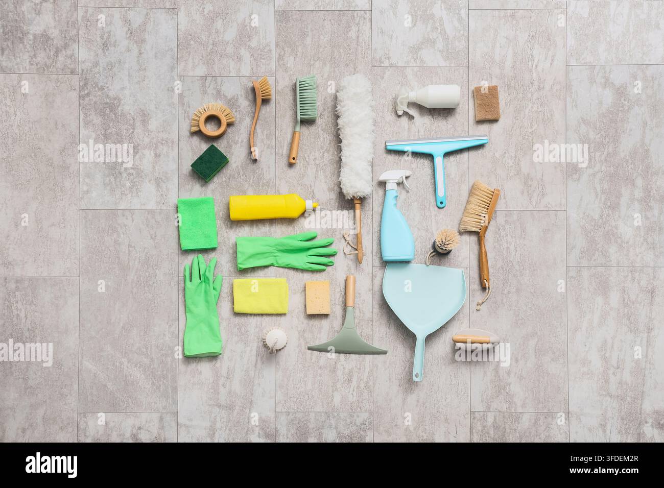 Pulizia della casa e manutenzione domestica, raccolta di vari prodotti e strumenti di pulizia ecologici disposti su un pavimento piastrellato grigio per le pulizie di primavera Foto Stock