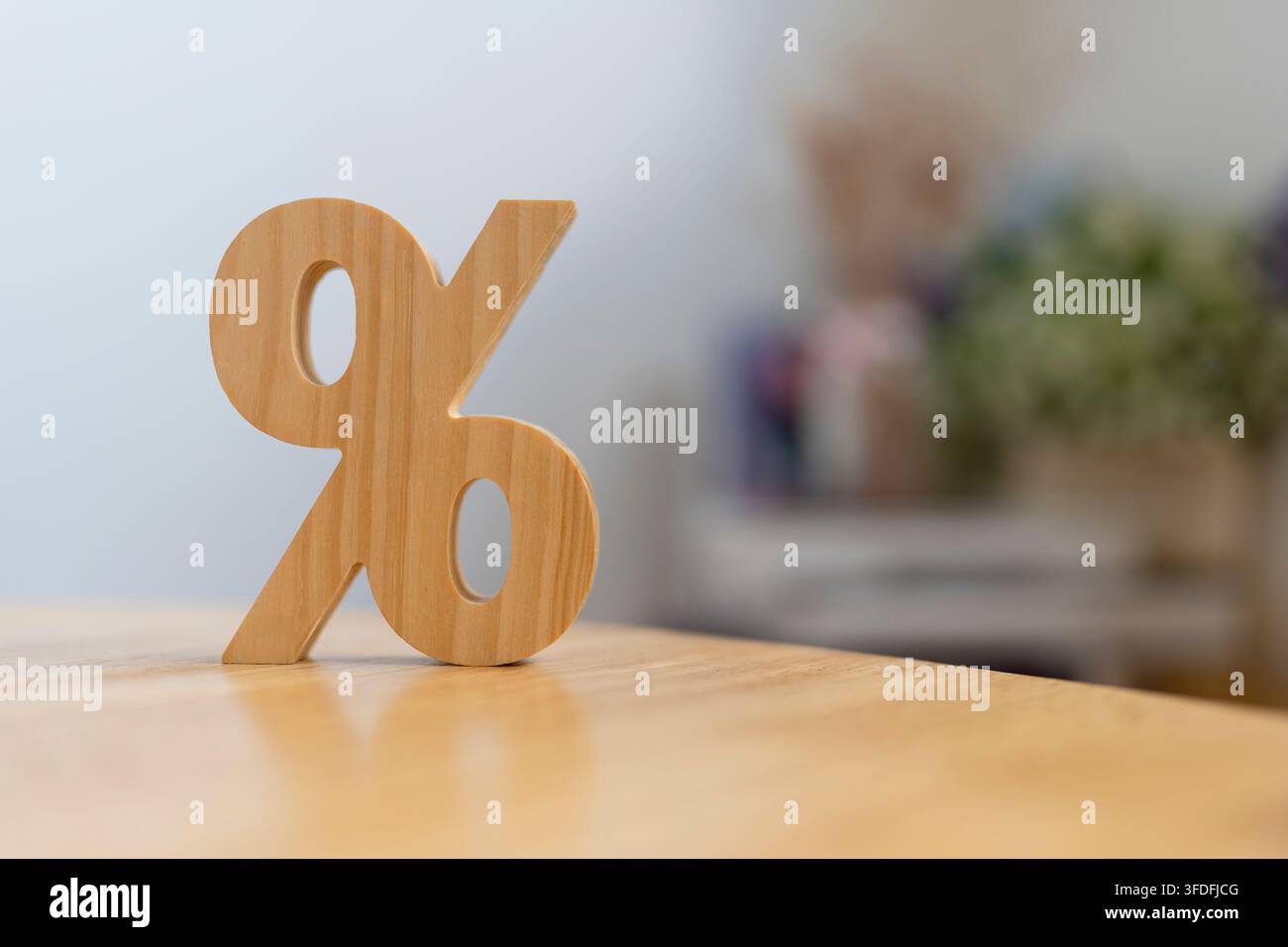 Concetto di tasso di interesse e percentuale di sconto con simbolo percentuale in legno sul tavolo contro uno sfondo sfocato luminoso e morbido per il calcolo del prestito finanziario, Foto Stock