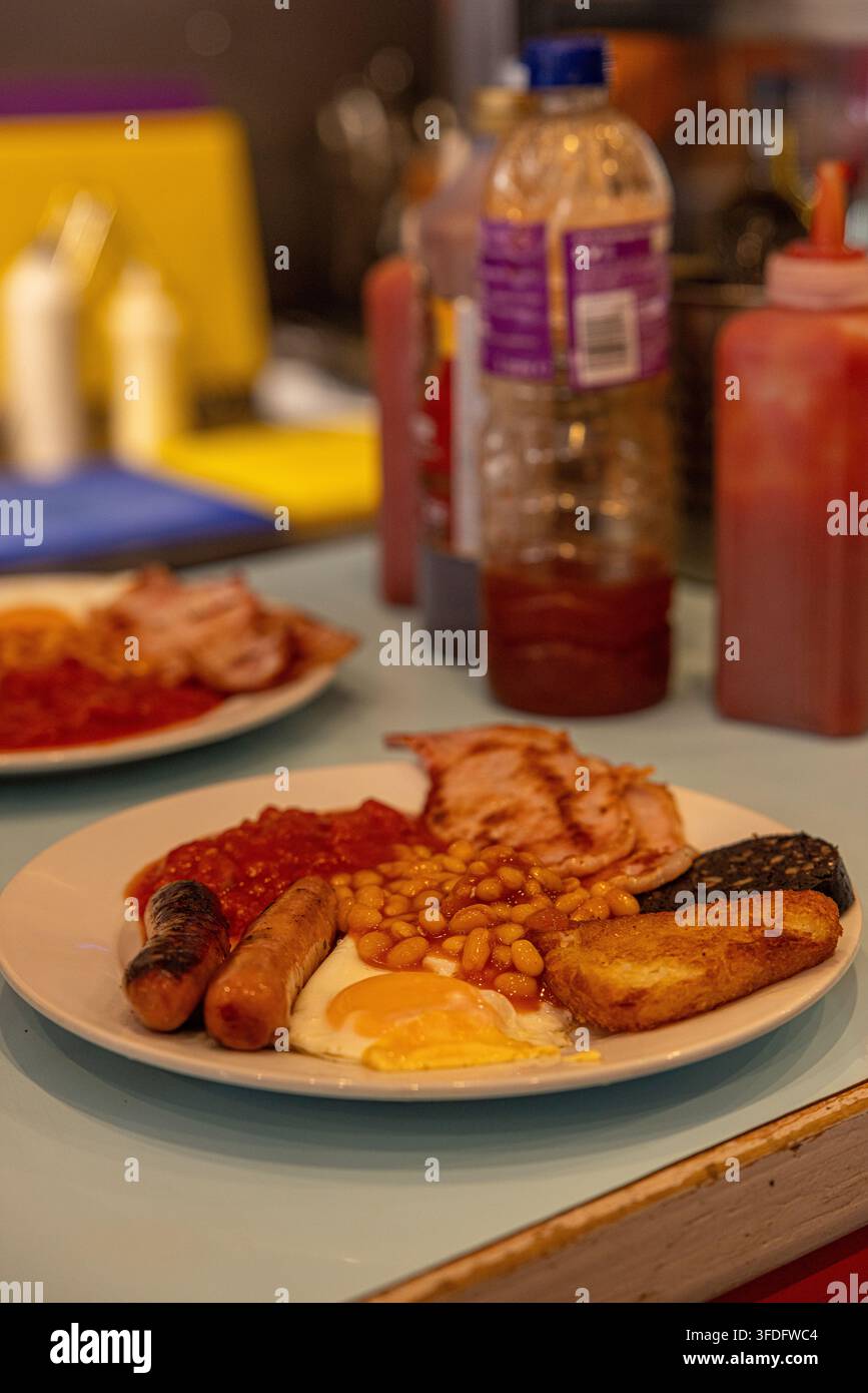 Classica colazione inglese tradizionale completa servita su un piatto in un caffè. Foto Stock