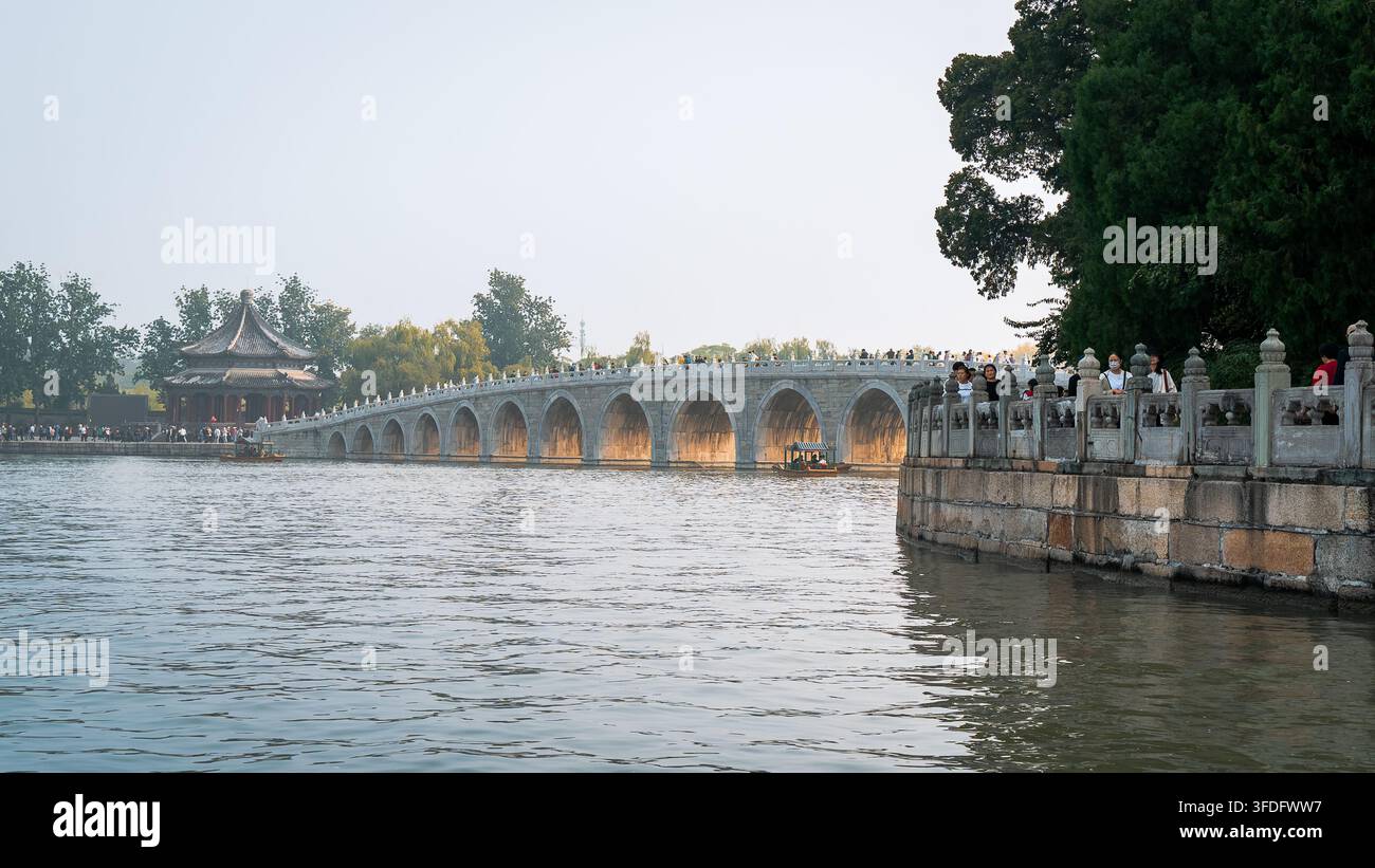 Il ponte storico con diciassette archi che attraversa il lago Kunming al Palazzo d'Estate di Pechino, in Cina, che mostra un'elegante architettura della dinastia Qing e tranquilla Foto Stock