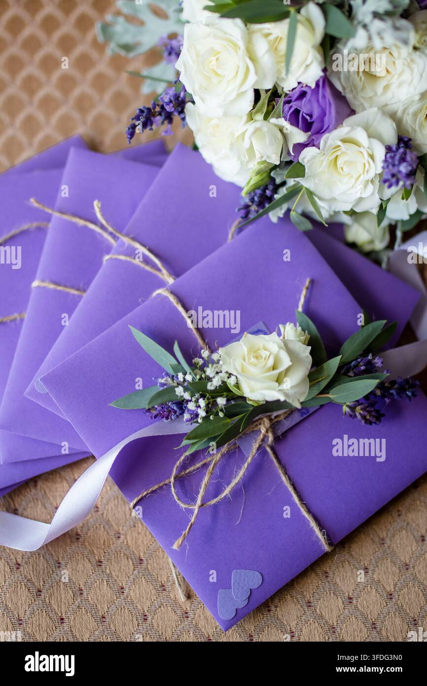 Eleganti inviti di nozze viola con fiori freschi Foto Stock