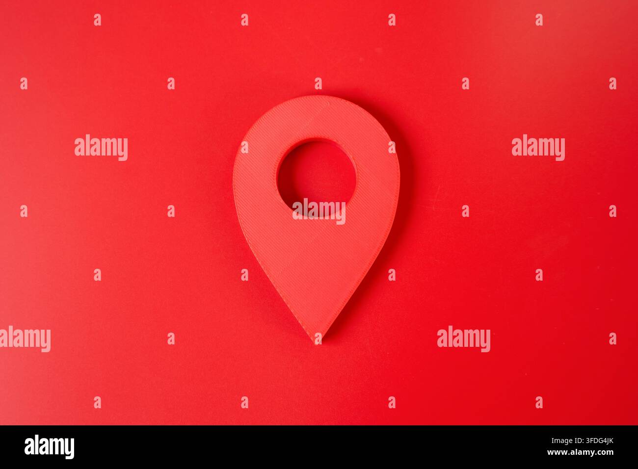 Pulsante con spilla di localizzazione rossa su sfondo rosso. Concetto minimalista di luogo e dintorni. Mappatura, navigazione e posizionamento geografico identificano un s Foto Stock