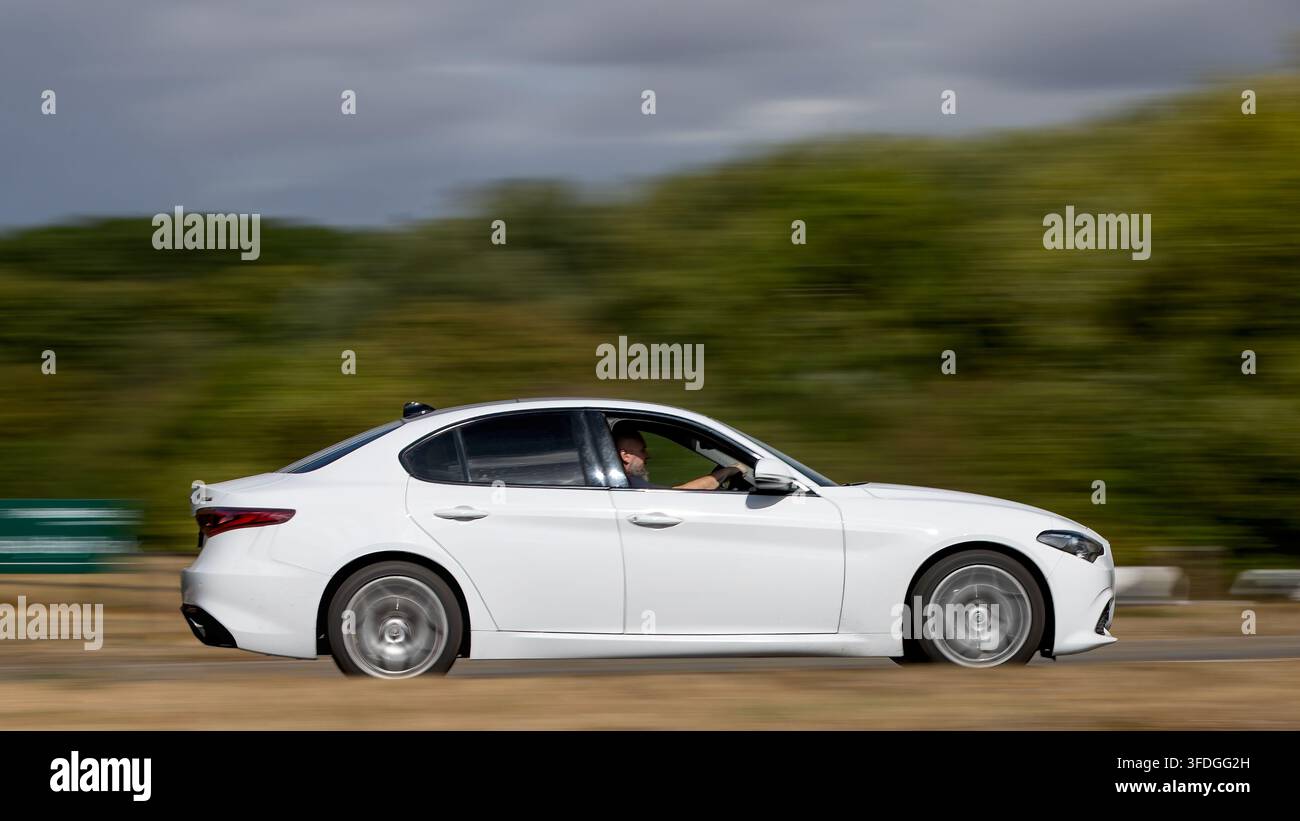 Milton Keynes; Regno Unito - 26 agosto 2026: auto bianca Alfa Romeo Giulia in corsa su una strada britannica Foto Stock