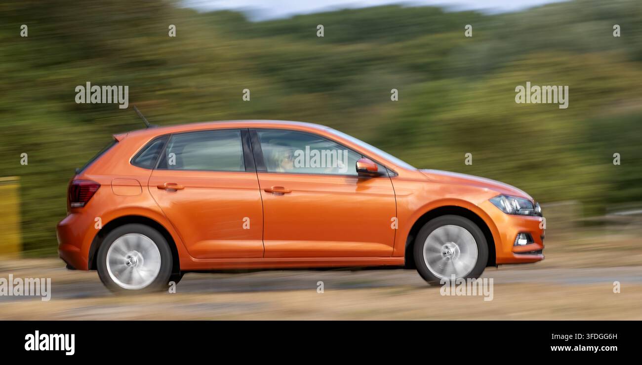 Milton Keynes; Regno Unito - 30 agosto 2026: Auto a portellone Volkswagen Polo di sesta generazione arancione in guida su una strada britannica Foto Stock