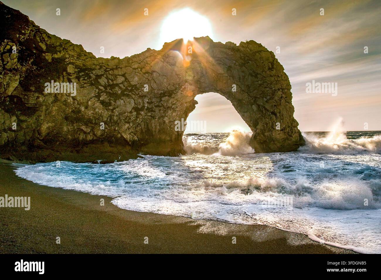 Tramonto su Durdle Door Dorset UK mentre mari tempestosi si infrangono attraverso l'arco di calcare Foto Stock