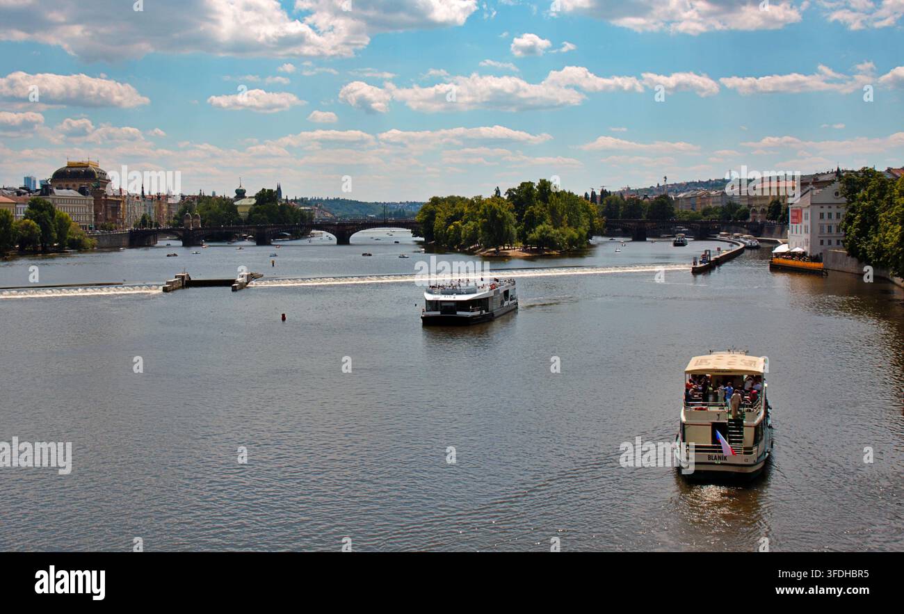 Praga, Repubblica Ceca – 28 luglio 2026: Vista panoramica del fiume Moldava con barche turistiche, ponti e il paesaggio urbano storico di Praga. Foto Stock