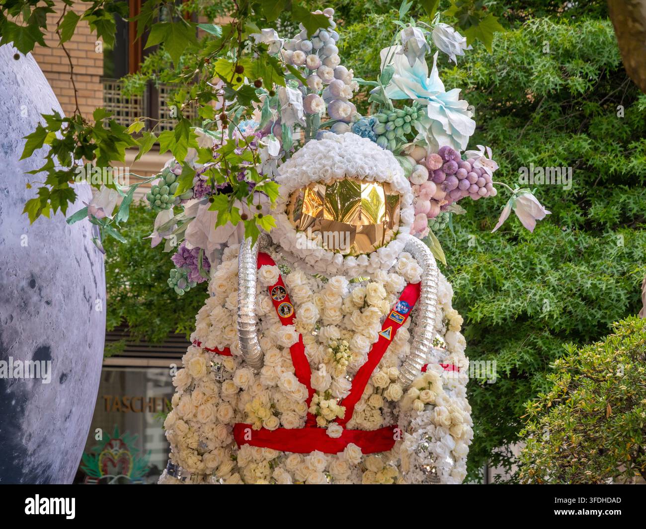Astronauta ricoperto di fiori con una luna gigante su Duke of York Square a Chelsea nella mostra Moon Landing di Chelsea in Bloom 2026. Foto Stock